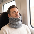 Man dozing on a train wearing the Solvrly Wrap Travel Pillow