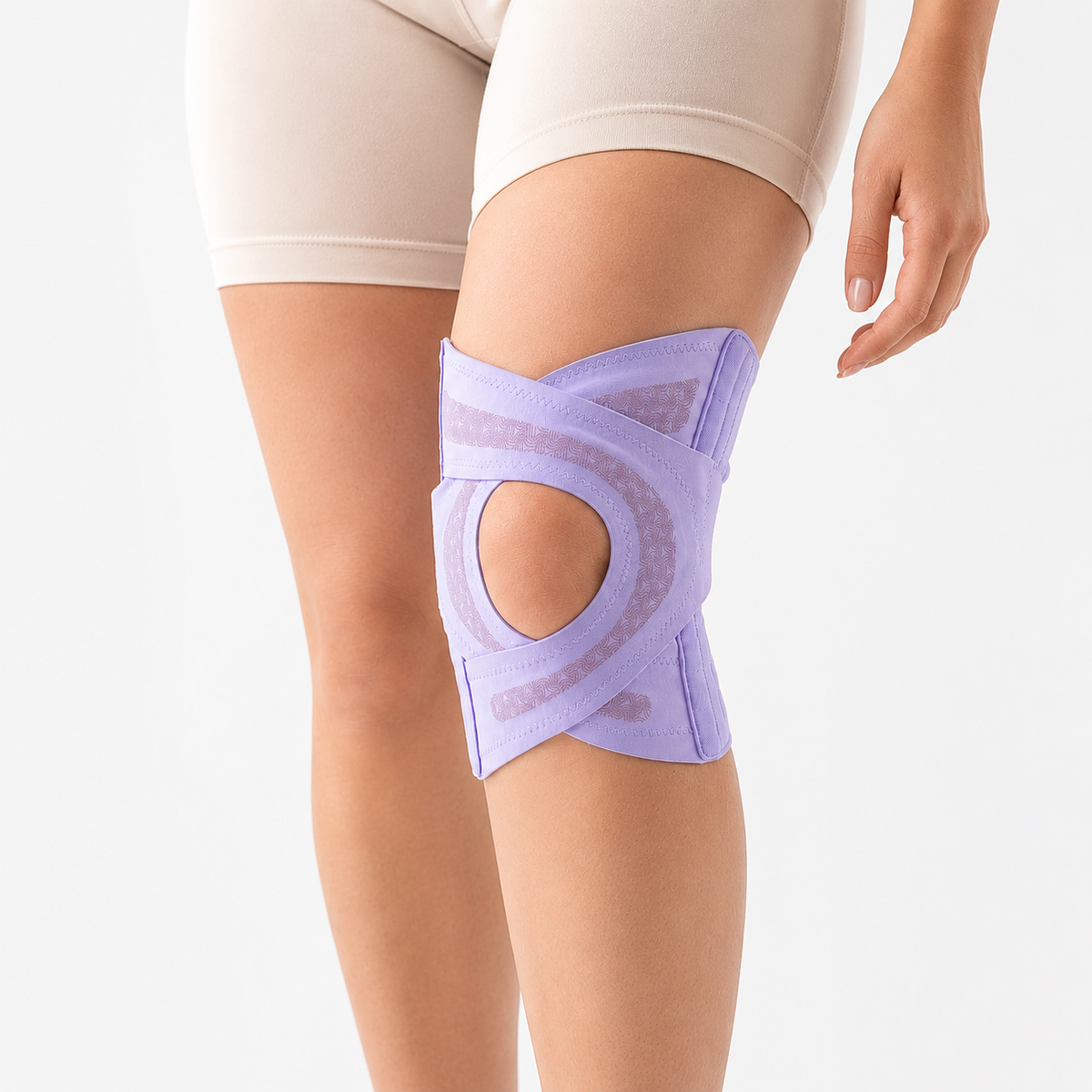 The Solvrly Pivot knee brace in purple worn on a bent knee, showing the cross straps and open kneecap